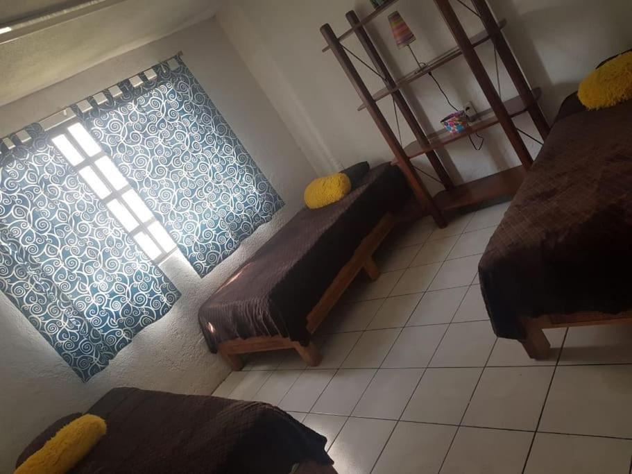 a small room with two beds and a window at Residencia paraíso in Temixco