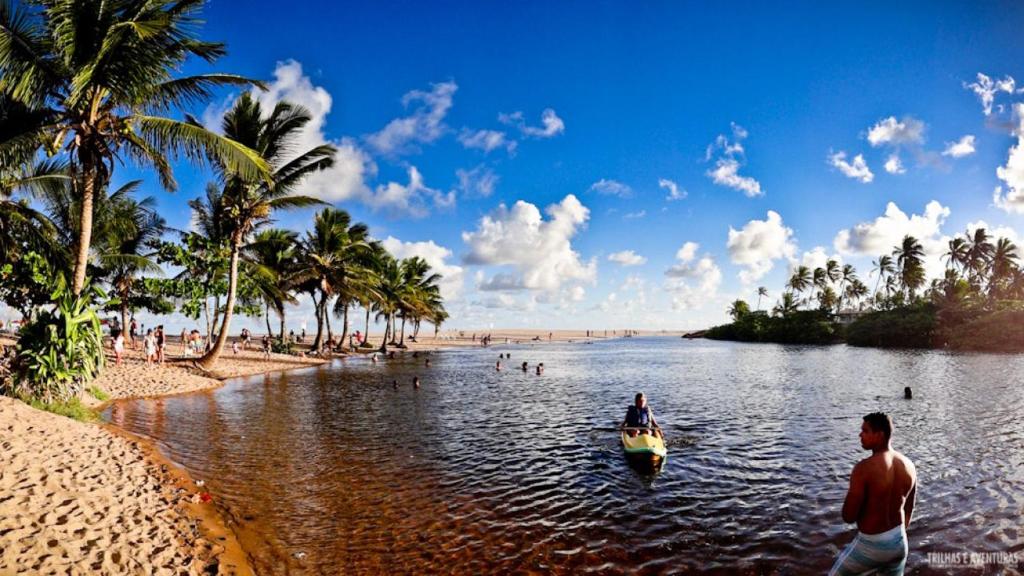 ein paar Leute in einem Boot im Wasser am Strand in der Unterkunft Imbassai - Casa Alto Padrão completa - Condominio Fechado - A2B1 in Imbassai