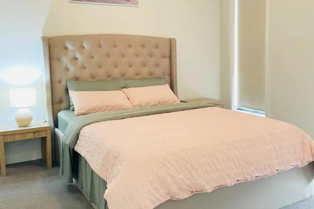 a bedroom with a large bed with a pink bedspread at Entire 4 Bedroom Brand New Home In Melton South ! in Melton South