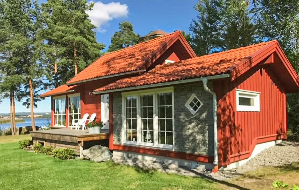um pequeno chalé vermelho com um telhado vermelho em Stunning Home In Arvika With Kitchen em Arvika