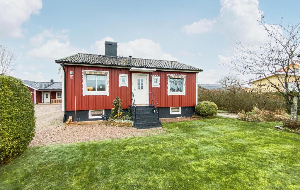 una casa roja con césped delante en Lovely Home In Laholm With Wifi, en Laholm