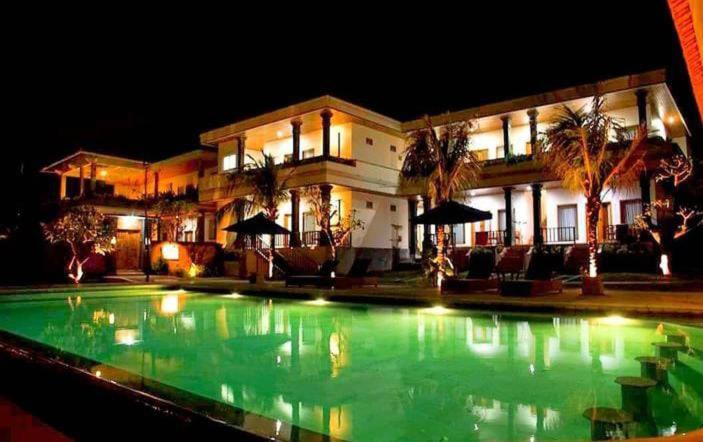 - une grande piscine en face d'une maison la nuit dans l'établissement Davu Sundara Villa Uluwatu, à Uluwatu