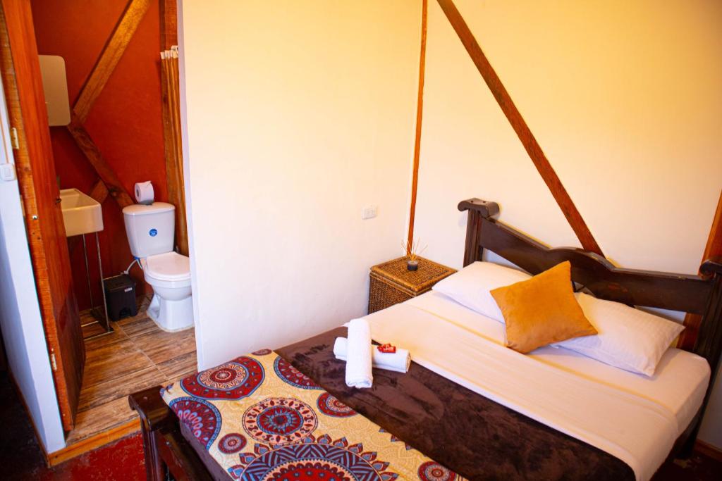 a bedroom with a bed and a toilet in a room at Kimaná Hostal in Santa Rosa de Cabal