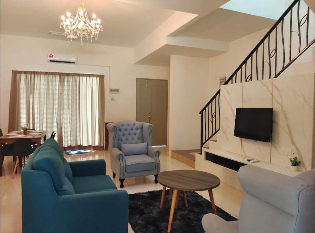 ein Wohnzimmer mit einem Sofa, Stühlen und einem TV in der Unterkunft ZaraVip homestay in Lahat