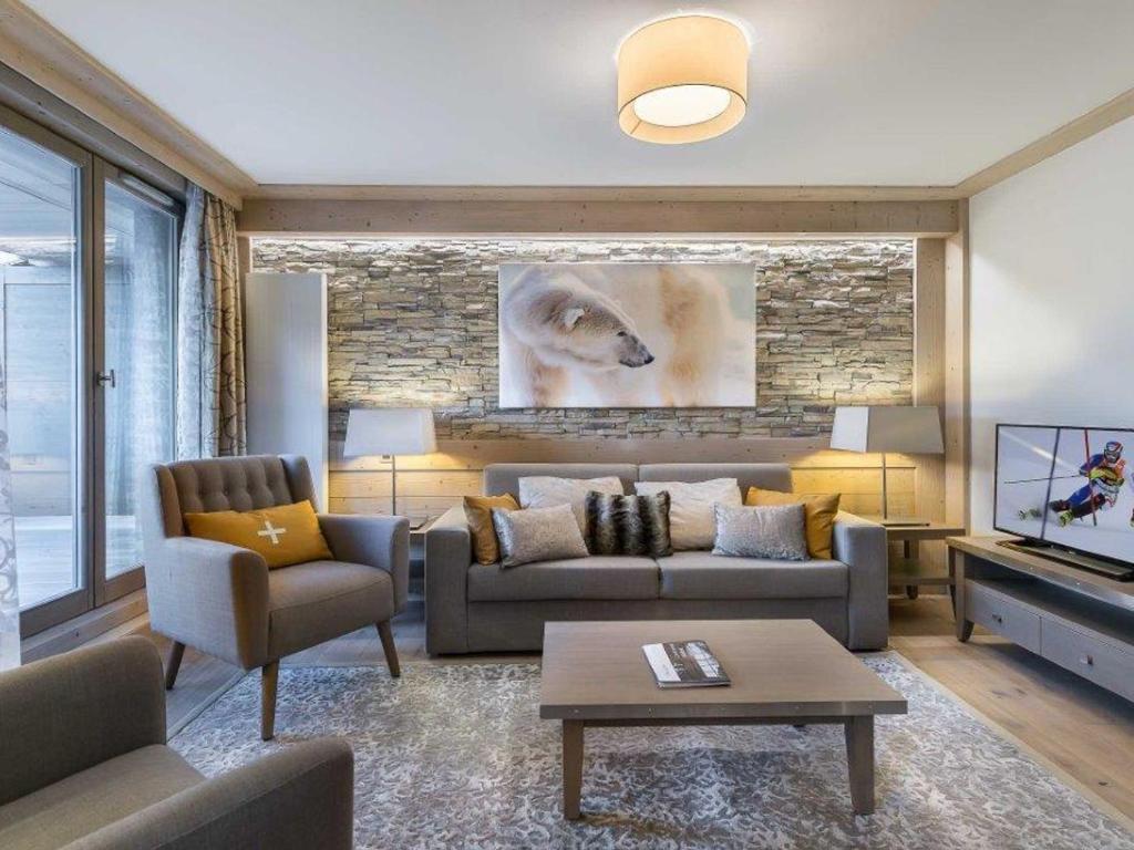 a living room with a couch and a tv at Appartement Courchevel 1550, 3 pièces, 6 personnes - FR-1-562-64 in Courchevel