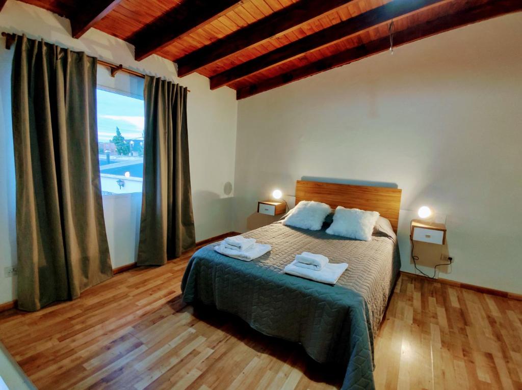 Un dormitorio con una cama y una ventana grande. en Centro RG, en Río Gallegos