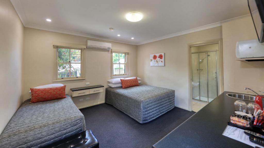 a small room with two beds and a sink at Prince Of Wales Hotel Gulgong in Gulgong