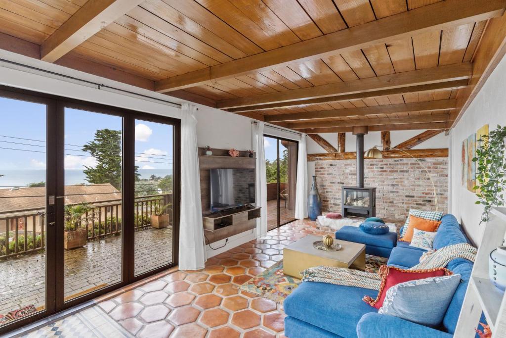 帕西菲卡的住宿－@ Marbella Lane - 3BR Home w/sweeping ocean views!，客厅设有蓝色的沙发和壁炉