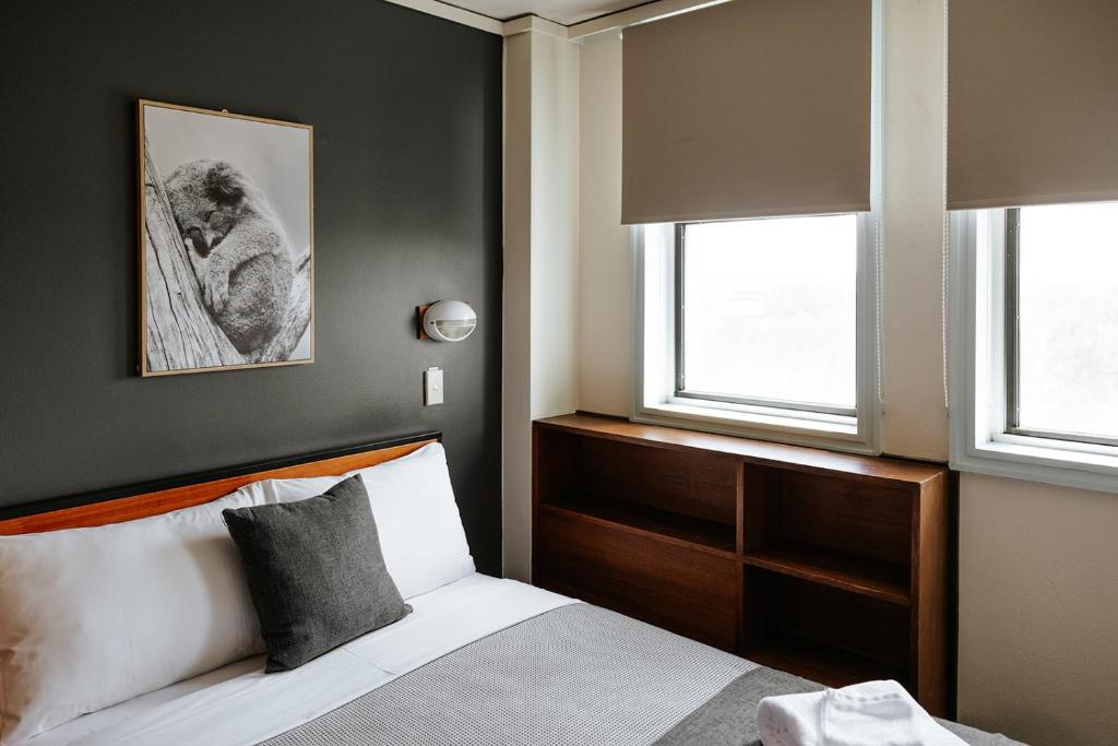 um quarto com uma cama e duas janelas em Canberra Accommodation Centre em Canberra