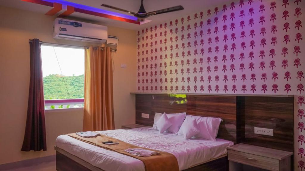 Un dormitorio con una cama con una pared rosa. en Hills And Sea View, en Port Blair