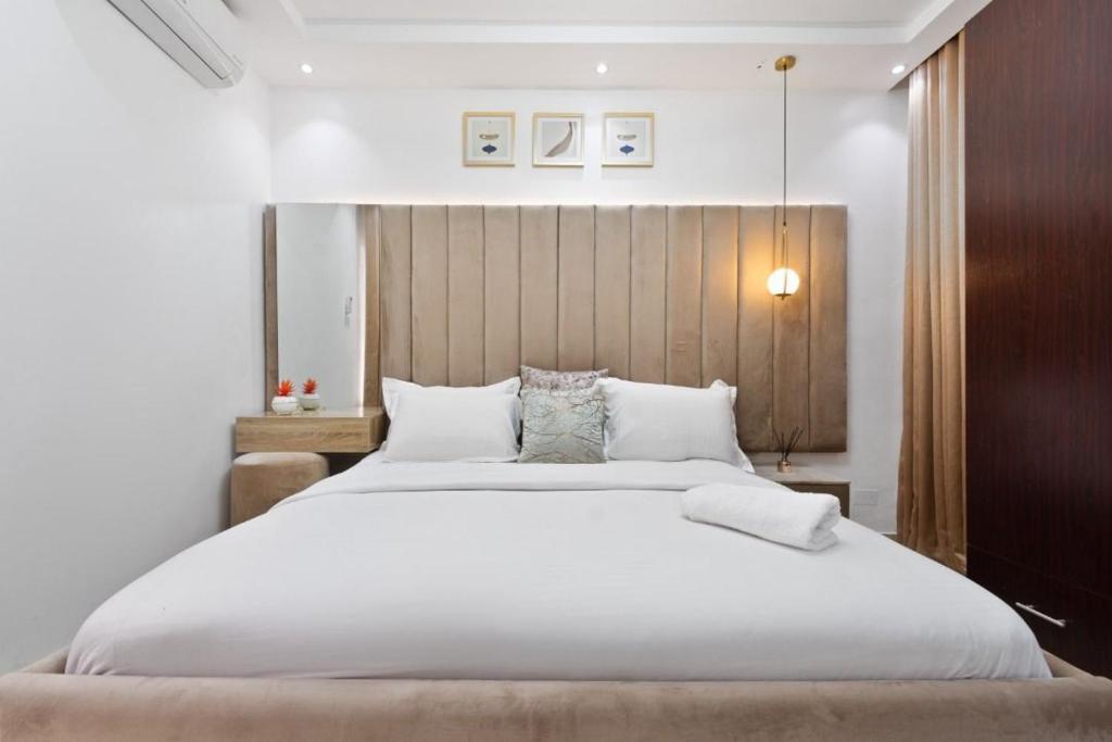 1 dormitorio con 1 cama grande con sábanas y almohadas blancas en Luxury 3 Bedroom Apartment In Lekki Phase1, en Lekki