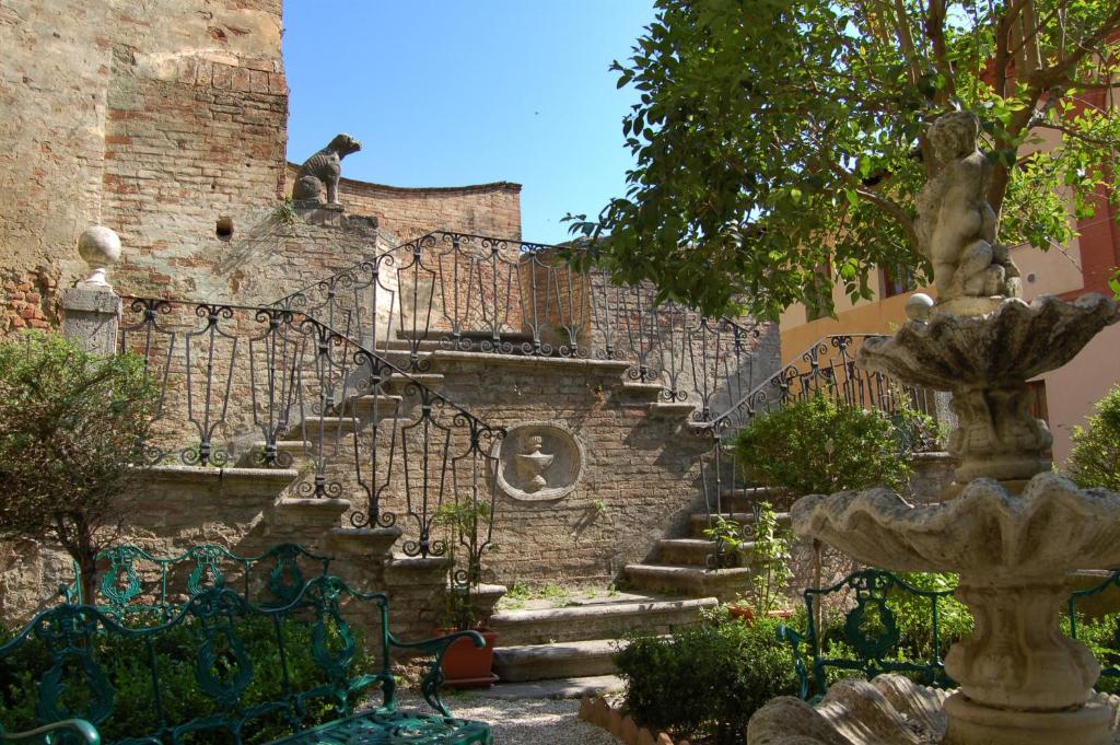 una escalera de piedra con un gato sentado en la parte superior de un edificio en BnB Residenza d Epoca il Casato, en Siena