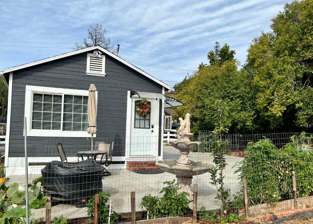 a black house with a fountain in a garden at Your Most Romantic and Peaceful Getaway in El Sobrante