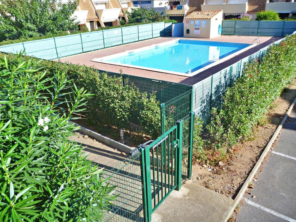 een hek naast een zwembad met een hek bij Appartement Marseillan-Plage, 2 pièces, 4 personnes - FR-1-387-70 in Marseillan