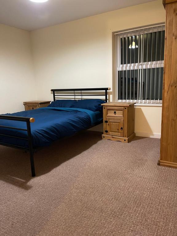- une chambre avec un lit bleu et une fenêtre dans l'établissement Two bedroom Entire Apartment in Roman road with Free Parking, à Middlesbrough