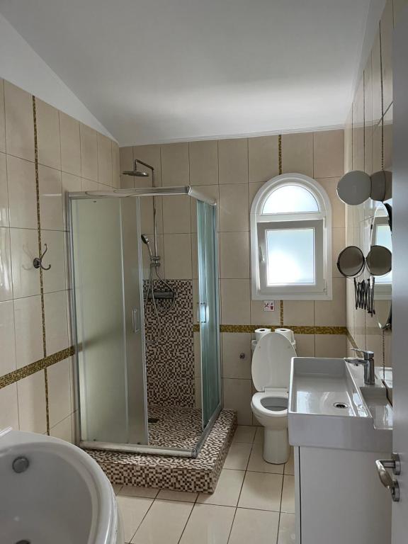 a bathroom with a shower and a toilet and a sink at Villa Neyla Four bedroom Coral Bay Beach front in Coral Bay