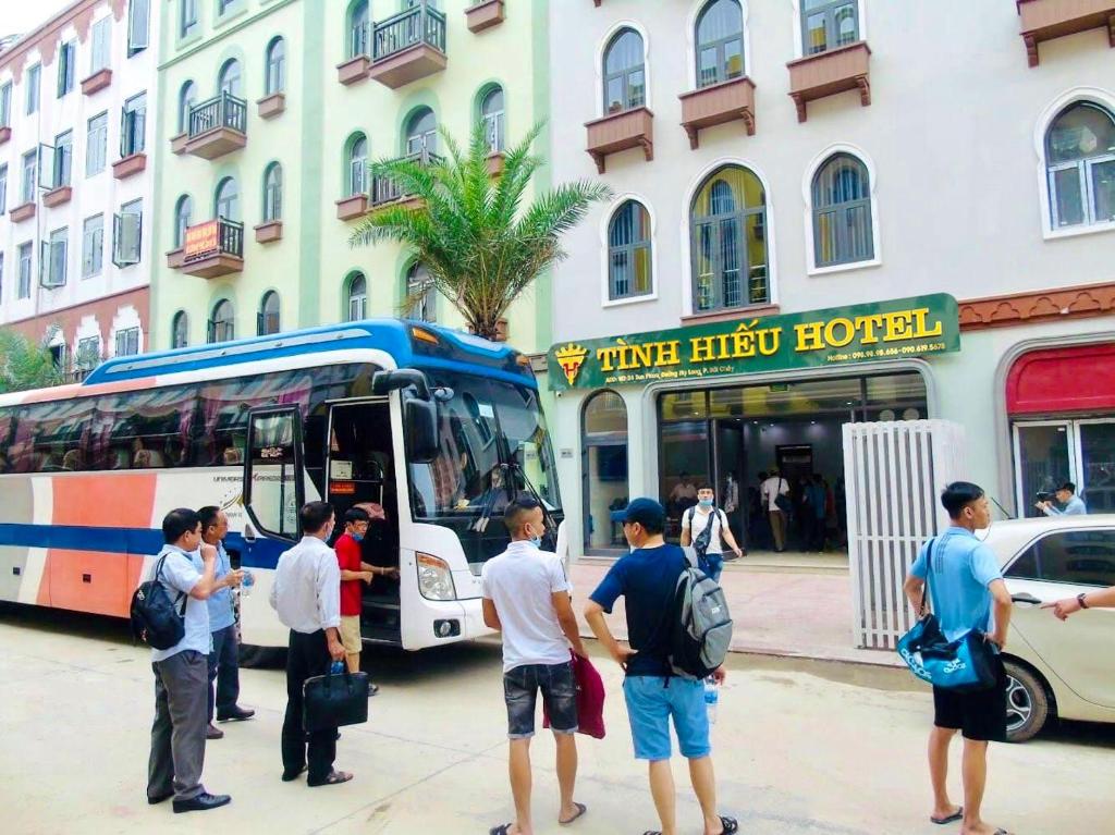 un grupo de personas parados fuera de un autobús en Tình Hiếu Hotel en Ha Long