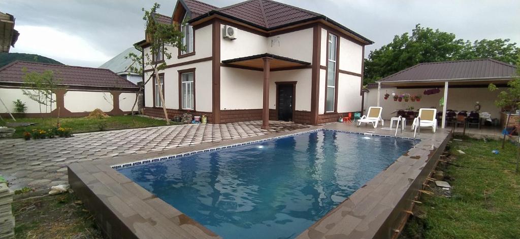 ein Haus mit einem Pool vor einem Haus in der Unterkunft Family villa in Qabala in Qəbələ