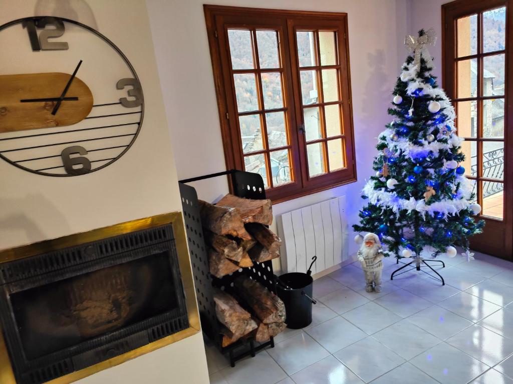 una sala de estar con un árbol de Navidad y una chimenea en gite boutx 10 personnes, en Boutx