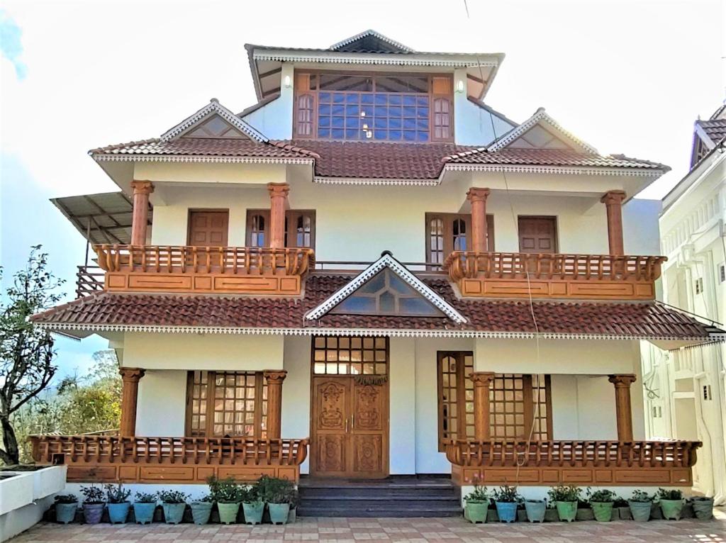 a house with wooden balconies on top of it at Pears Garden Royal Suite in Kodaikānāl