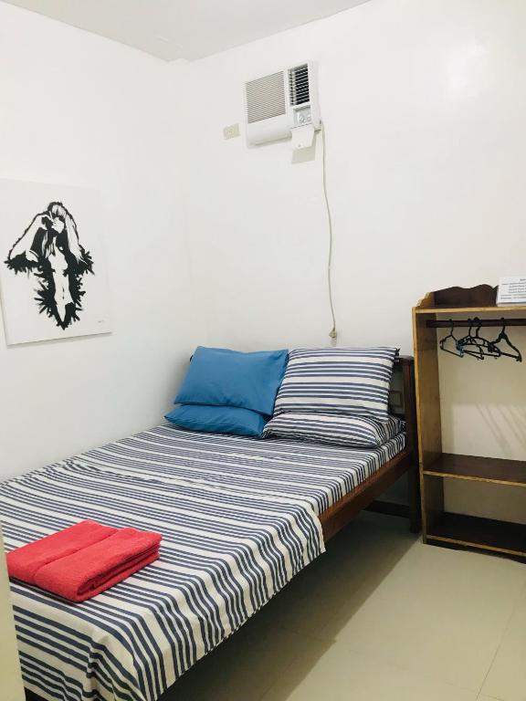 a bed in a room with a red towel on it at Queen's Room Rental 3 in El Nido