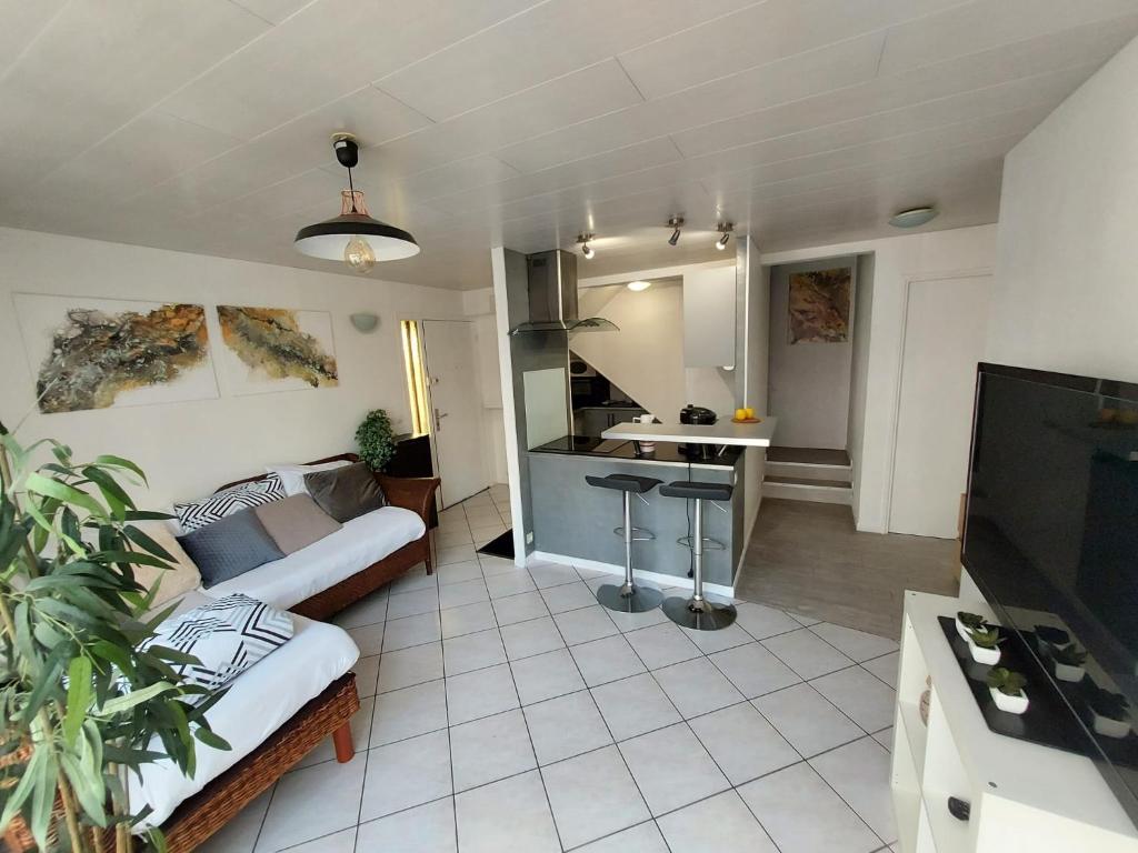 a living room with a couch and a kitchen at Super t6 avec terrasse à Cergy in Cergy