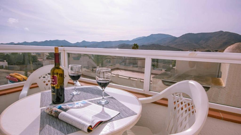 a bottle of wine and two glasses on a table on a balcony at Casas María Carmona - Casa Luna Níjar by Ruralidays in Níjar
