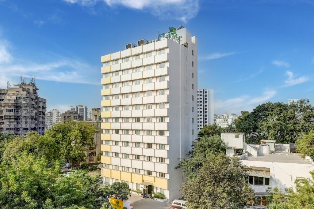 un edificio blanco alto con una persona encima en Lemon Tree Hotel, Ahmedabad en Ahmedabad