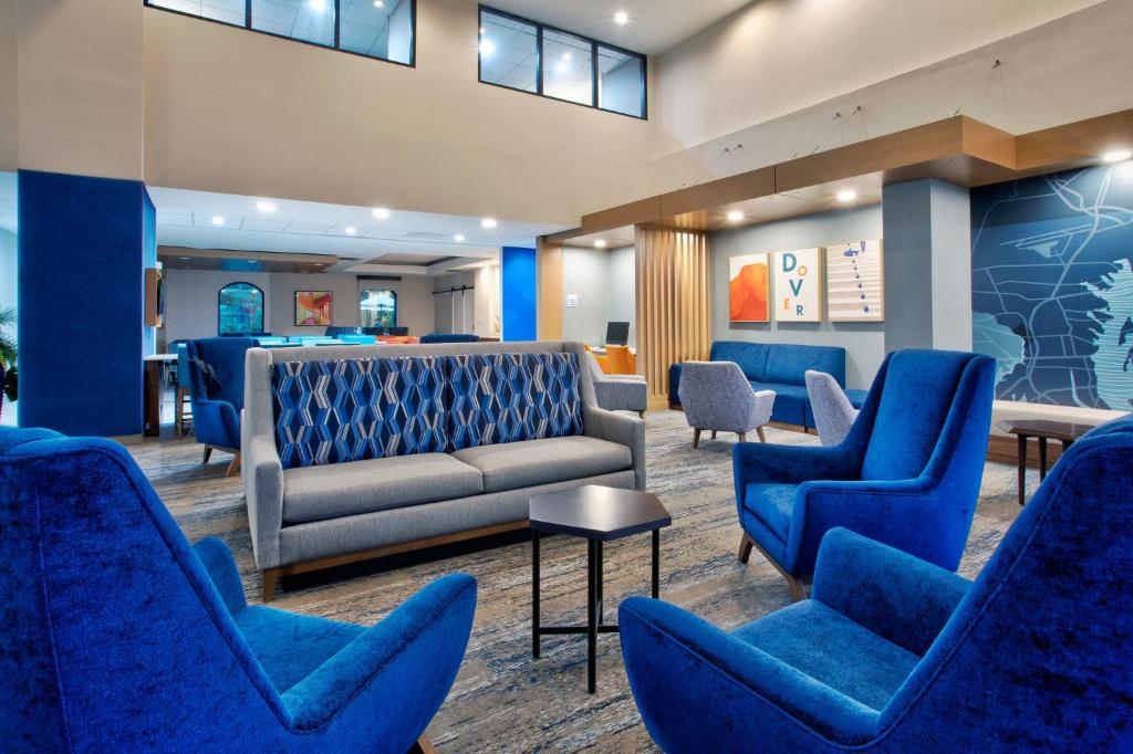a waiting room with blue chairs and a couch at Holiday Inn Express Hotel & Suites Dover by IHG in Dover