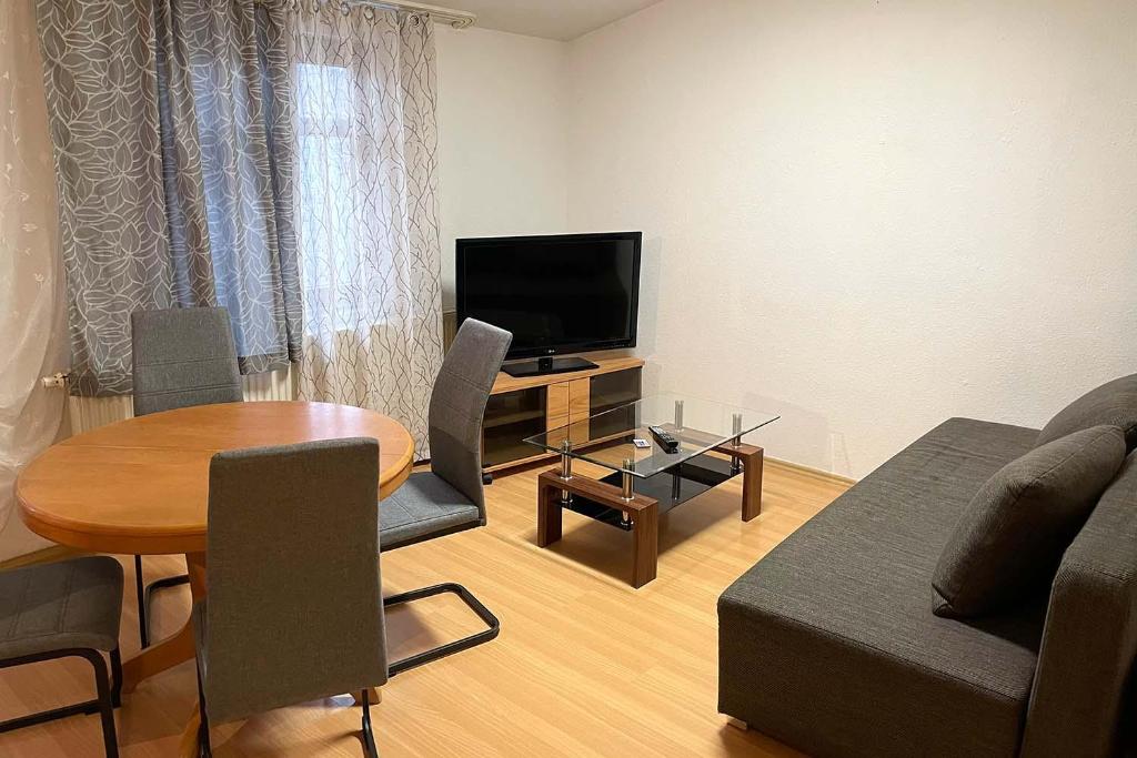 City apartment with Wifi near Jena في Kahla: غرفة معيشة بها أريكة وطاولة وتلفزيون