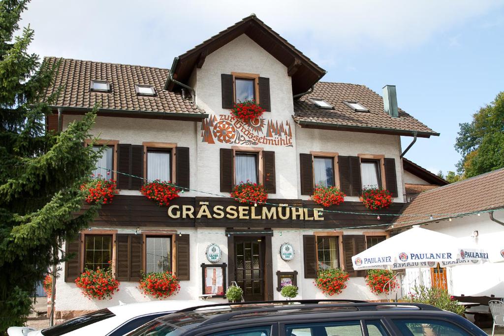 ein Gebäude mit einem davor geparkt in der Unterkunft Gasthaus zur Grässelmühle in Sasbach in der Ortenau