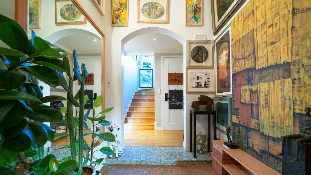 a hallway with arches and a wall with paintings at Museum Stay in Yongin