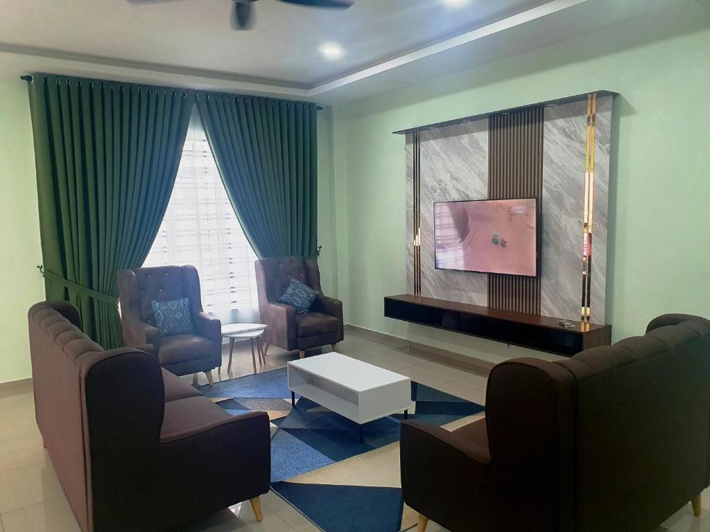 a living room with two chairs and a flat screen tv at RR Homestay in Kluang