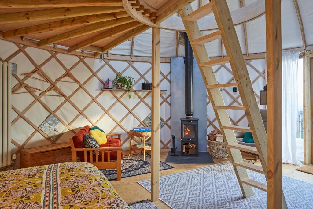 Niton的住宿－Puckaster Cove Luxury Yurt，蒙古包内带一张床和一个壁炉的房间