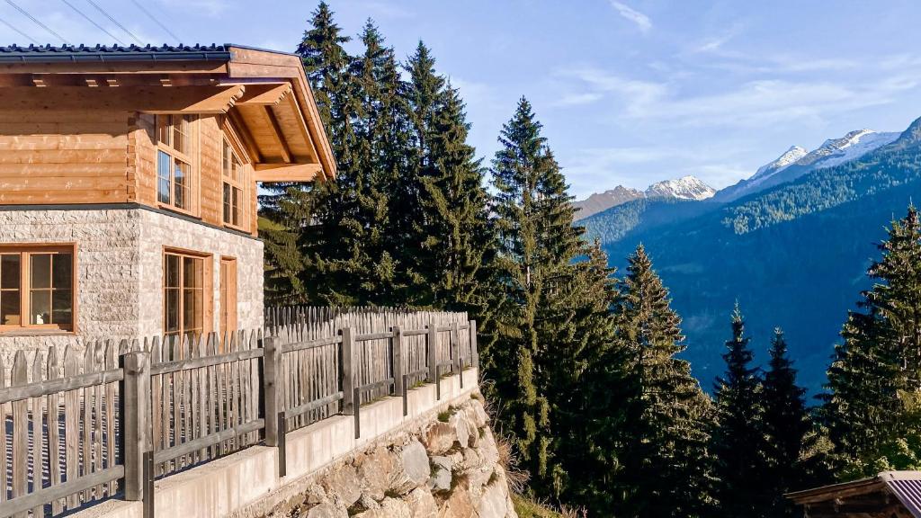 a house on the side of a mountain with a fence at Almchalet Wieslhütte in Gerlosberg