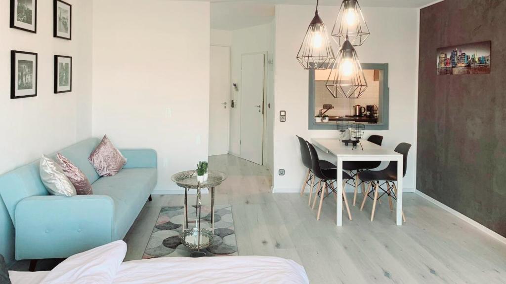 ein Wohnzimmer mit einem blauen Sofa und einem Tisch in der Unterkunft ✪ Beautiful Studio in Center with Amazing View ✪ in Mannheim