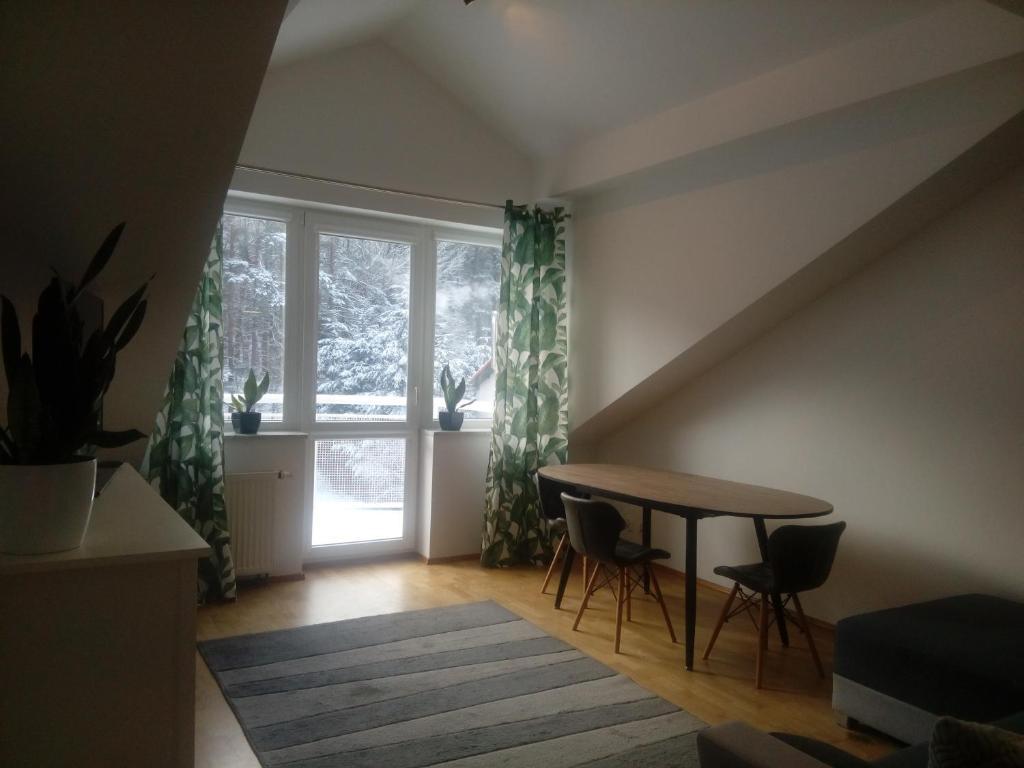 a dining room with a table and a window at Leśny Loft in Gdynia