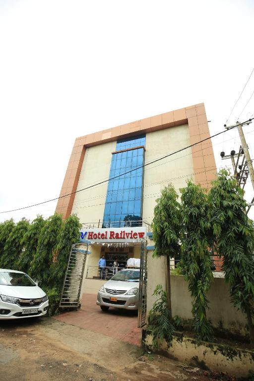a hotel building with cars parked in front of it at HOTEL RAILVIEW Bhubaneswar in Bhubaneshwar