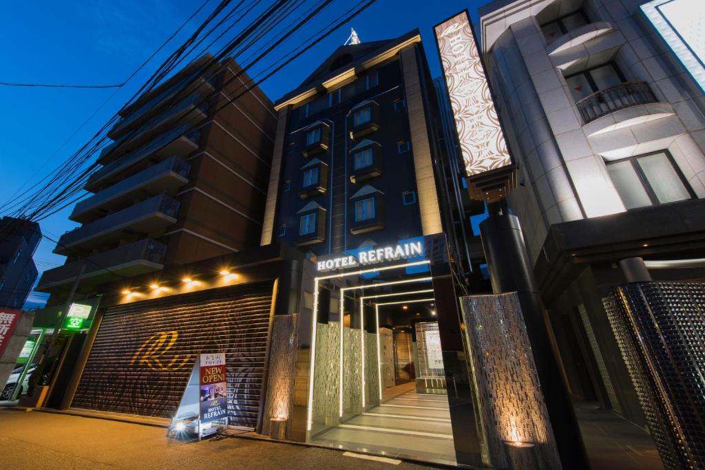 un exterior de hotel con una señal frente a un edificio en HOTEL REFRAIN, en Tokio
