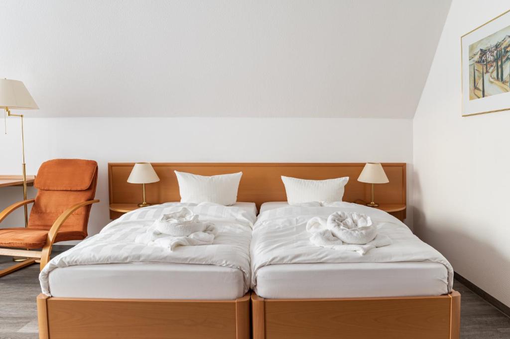 um quarto com 2 camas e toalhas em Löwen Pension em Unterlüß