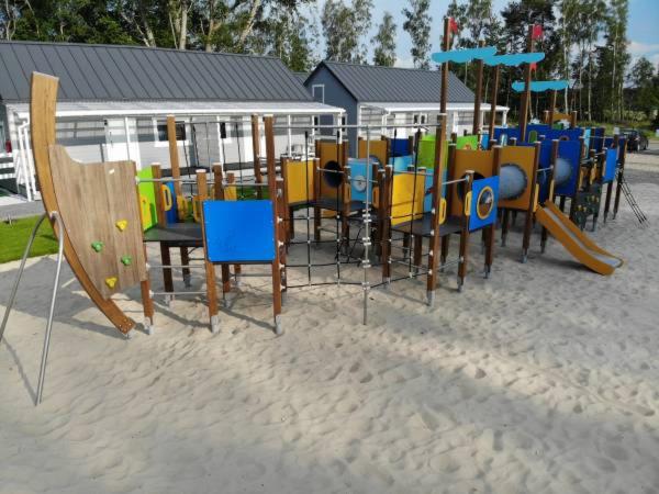 a playground with chairs and tables in the sand at Domki Dziwnów in Dziwnów