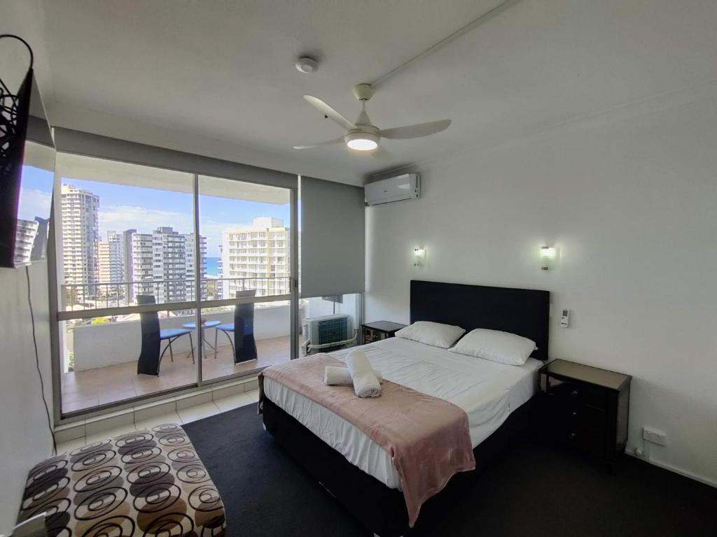 a bedroom with a bed and a large window at Golden Gate Resort in Gold Coast