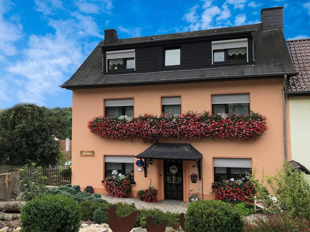 uma casa com flores ao lado dela em Pension Biewer em Ockfen