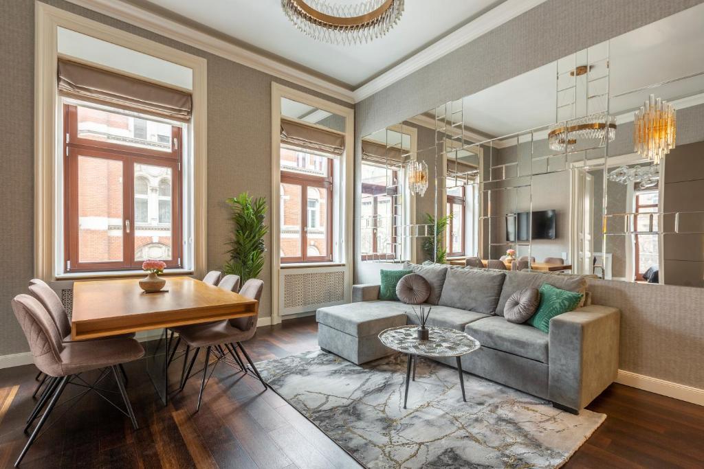 ein Wohnzimmer mit einem Sofa und einem Tisch in der Unterkunft Luxury Apartment With Balcony next to the New York Café in Budapest