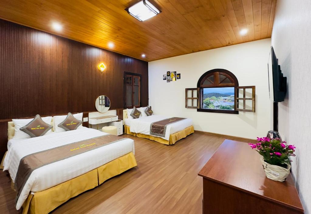 a hotel room with two beds and a television at Dalat Eco House in Trai Mat