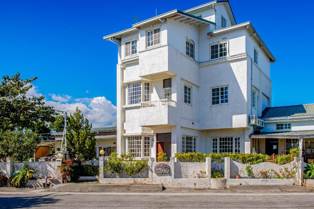 una casa bianca con una recinzione di fronte di Taitung Homeabout Pet Friendly Hall a Città di Taitung