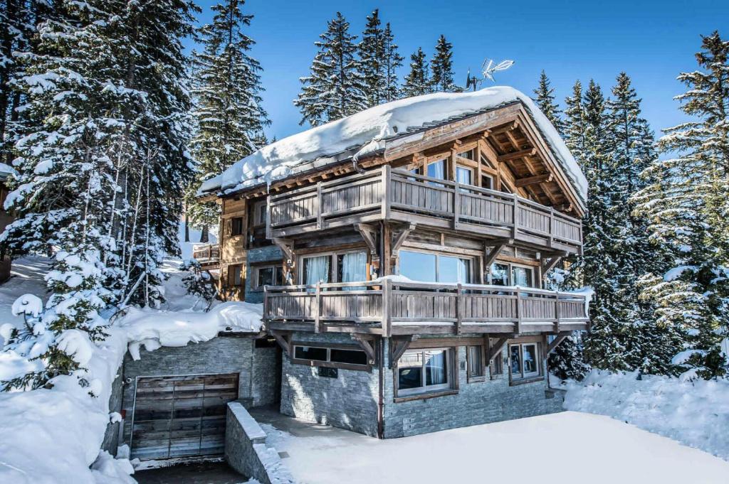 a log cabin in the snow with snow covered trees at Résidence Eden - Chalets pour 10 Personnes 754 in Courchevel