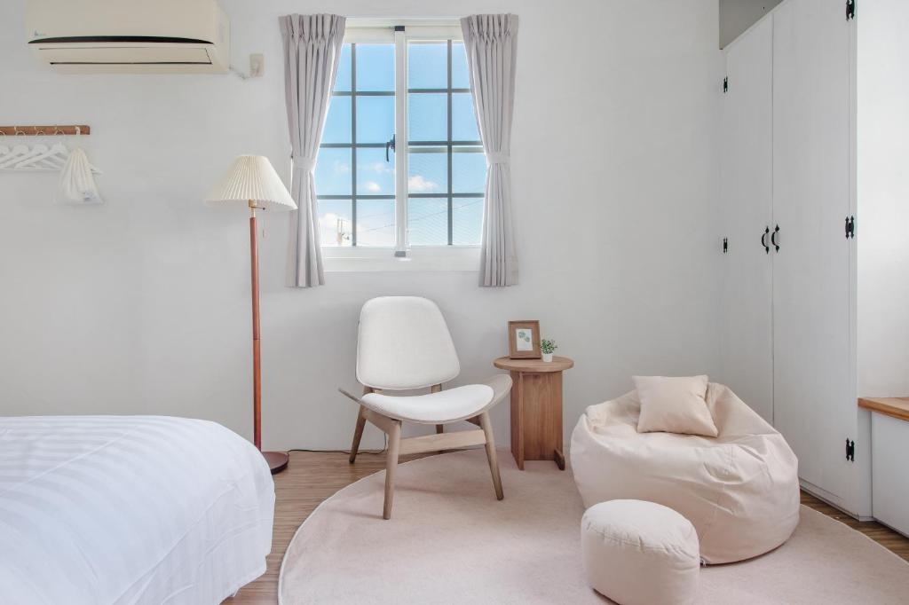una camera da letto con un letto, una sedia e una finestra di Taitung Homeabout Pet Friendly Hall a Città di Taitung