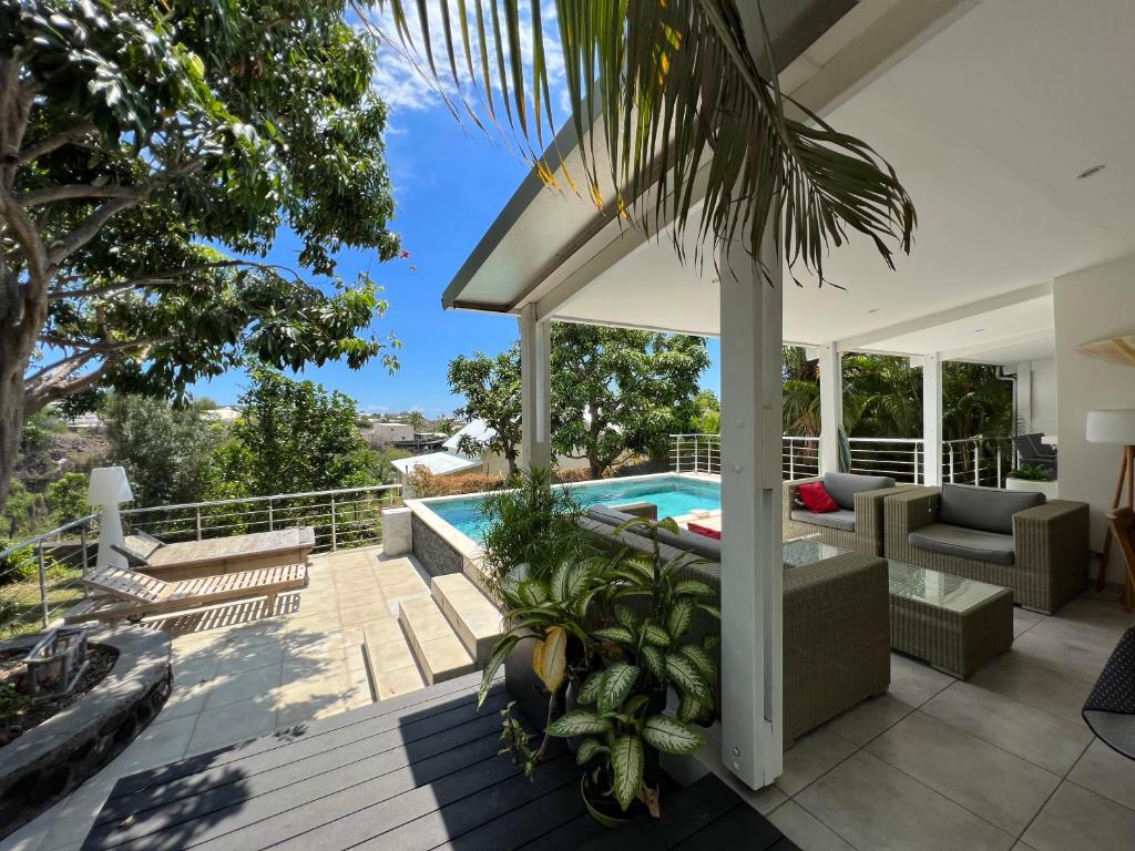 uma casa com uma piscina e um pátio em Villa tropicale - Meublé de Tourisme 4 Etoiles em Saint-Gilles-les Bains