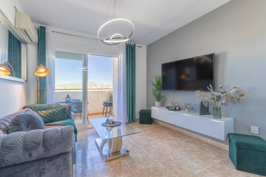 a living room with a couch and a tv at Calpe Vacaciones in Calpe